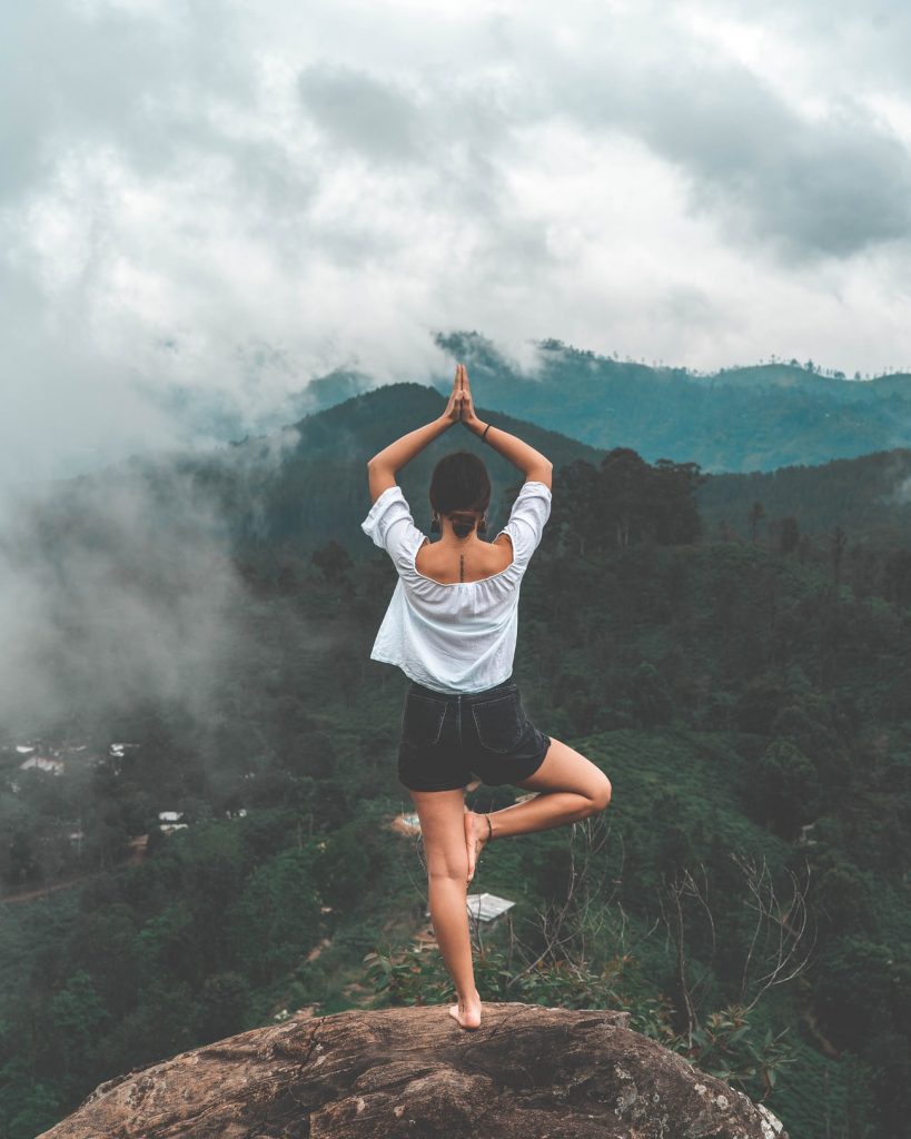 Woman doing yoga above jungle